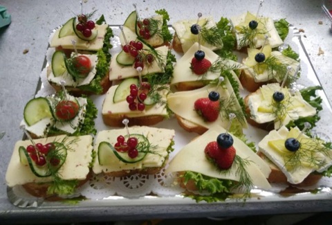 Halbe Brötchen mit Käse und Gurke, frisch mit Obst garniert